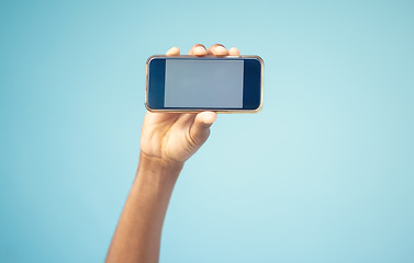 Image showing Phone, mockup screen and man hand advertising sale, promotion or brand on website or internet. Person with smartphone in hand on blue background studio for contact us, online contact or connection