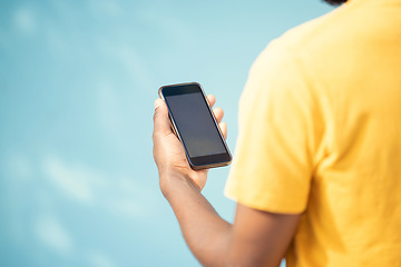 Image showing Hand, phone and mockup screen with man reading sale, promotion or email for brand on website. Person with smartphone on blue background in studio for about us, online contact or network connection