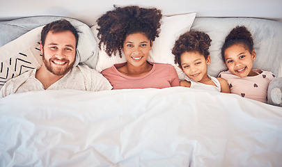 Image showing Family, happy and portrait in bed at home for quality time, bonding or morning routine. Above, mixed race and smile of a man, woman and children together in a bedroom with love, care and comfort