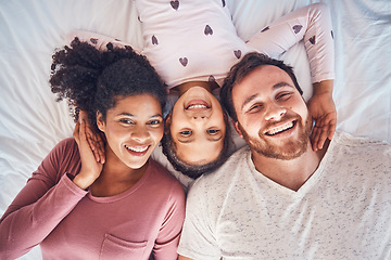 Image showing Smile, happy family and portrait on bed at home for quality time, bonding or morning routine. Above, mixed race and face of a man, woman and girl kid together in a bedroom with love, care and comfort