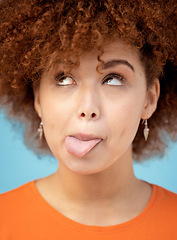 Image showing Comic, tongue and face with a black woman in studio on a blue background feeling funny or silly. Comedy, joke and humor with an attractive young female looking goofy while posing alone indoor