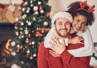 Image showing Christmas, portrait and happy couple in home, hug and bonding together. Xmas, smile and face of man with African woman, interracial and enjoying quality time for party, celebration and winter holiday