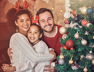 Image showing Christmas, happy family and portrait in home, hug and bonding together. Xmas, smile and face of parents with girl, interracial kid and African mom embrace father for party, celebration and holiday