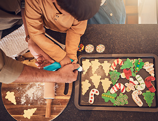 Image showing Christmas, above and a family baking cookies, help with food and process of decoration. Hands, child and teamwork for icing sweet dessert or biscuits for a festive holiday in the kitchen together