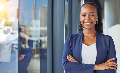 Image showing Portrait, window and arms crossed with a business black woman standing in her professional office. Smile, corporate leadership with a happy female manager or boss in the workplace for empowerment