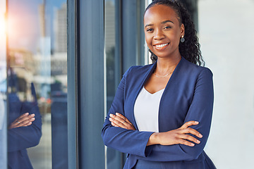 Image showing Portrait, window and arms crossed with a business woman standing in her professional office. Smile, corporate leadership with a happy african manager or boss in the workplace for empowerment