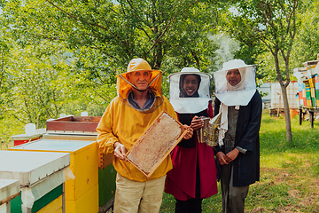 Image showing Arab woman investitors with an experienced senior beekeeper checking the quality and production of honey at a large bee farm