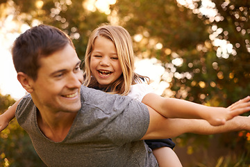 Image showing Where are we flying to today. Shot of a father giving his adorable daughter a piggyback ride.