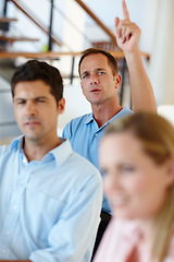 Image showing Could you repeat that statement please. Shot of workers sitting in the office with one colleagues hand raised.