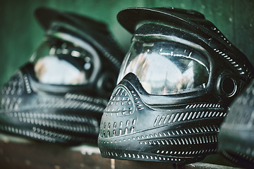 Image showing Mask, helmet and paintball with still life equipment on a table outdoor ready for combat training or war games. Safety, sports and military protection with uniform headwear closeup for competition