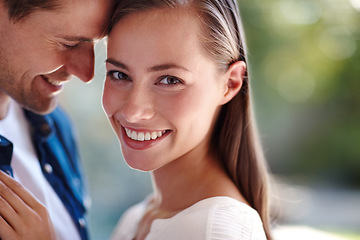 Image showing She means the world to him. A young man holding his girlfriend while standing outdoors on a sunny day.