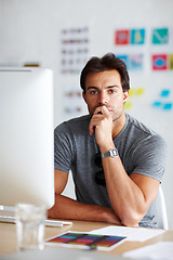 Image showing Thinking creative thoughts. A handsome young man sitting in front of his computer looking pensive.