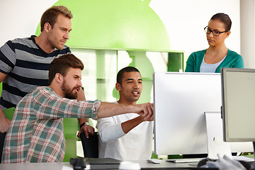 Image showing Creative collaborators. Shot of a group of young designers working together at a computer.