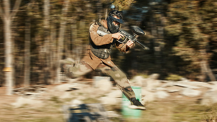 Image showing Paintball, shooting and jump with man in playground for battlefield, mission and soldier. Sports, games and fast with person and gun gaming in arena for challenge, adventure and warrior training