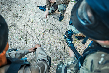 Image showing Paintball, battlefield and team building with game plan, mission and strategy drawing in sand with soldier group. War, gun and plan attack, people outdoor and military tactics and army with teamwork