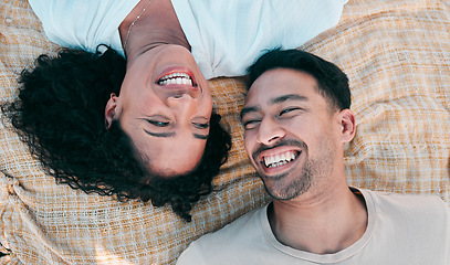 Image showing Face, picnic and smile with a couple laughing on a blanket from above, lying on the ground while on a date. Love, happy or funny with a man and woman bonding together for romance on valentines day