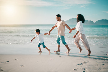 Image showing Running, flare and a family holding hands on the beach while walking during travel, vacation or bonding. Love, children and parents on sand at the coast by an ocean or sea for summer holiday fun