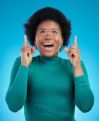 Image showing Hands, pointing up and black woman with wow news in studio for promo, announcement or deal on blue background. Omg, surprise and African female model show sale, coming soon or how to sign up steps
