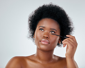 Image showing Black woman, makeup and brush for mascara or beauty with afro against a white background in studio. Face of African person or model applying eye product, cosmetics or lashes for facial treatment