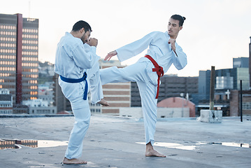 Image showing Men, fight and kick in karate class, training and speed with sparring partner, workout and morning on city rooftop. Martial arts team, contest and fitness with block for exercise, coaching or sports