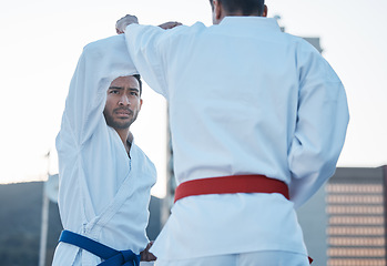 Image showing Karate, fight and men in city for exercise, workout and training outdoor. Martial arts, sports and people in competition for taekwondo, serious battle or combat challenge for healthy body in fitness