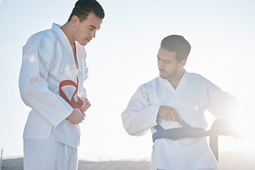 Image showing Karate men, teacher and tie belt with talk, questions and help for clothes, uniform for martial arts class in sunshine. Friends, training and sensei with chat for advice, guide and together for mma