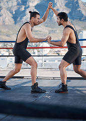 Image showing Strong men, wrestling and push in ring with challenge, holding hands and focus for contest in Cape Town. Athlete, martial arts and grappling for mma, competition or fight in combat workout on rooftop