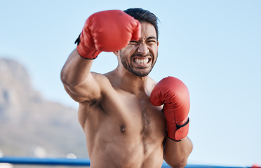 Image showing face, man or angry boxer punching in training, exercise or workout with strong boxing power outdoors. Serious fighter, fitness or Asian combat sports athlete fighting in mma practice match with pain