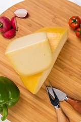 Image showing Bosnian traditional cheese served on a wooden container with peppers, parade and onions isolated on a white background