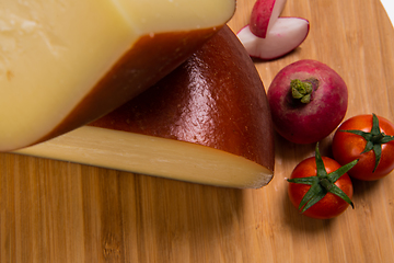 Image showing Bosnian traditional cheese served on a wooden container with peppers, parade and onions isolated on a white background