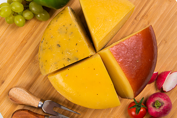 Image showing Bosnian traditional cheese served on a wooden container with peppers, parade and onions isolated on a white background