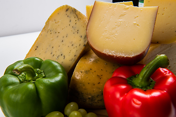 Image showing Bosnian traditional cheese served on a wooden container with peppers, parade and onions isolated on a white background