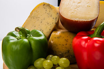 Image showing Bosnian traditional cheese served on a wooden container with peppers, parade and onions isolated on a white background