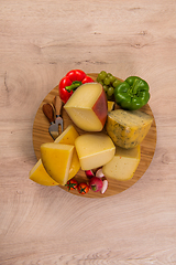 Image showing Bosnian traditional cheese served on a wooden container with peppers, parade and onions isolated on a white background