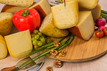 Image showing Bosnian traditional cheese served on a wooden container with peppers, parade and onions isolated on a white background