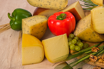 Image showing Bosnian traditional cheese served on a wooden container with peppers, parade and onions isolated on a white background