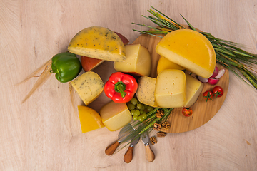 Image showing Bosnian traditional cheese served on a wooden container with peppers, parade and onions isolated on a white background