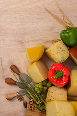 Image showing Bosnian traditional cheese served on a wooden container with peppers, parade and onions isolated on a white background