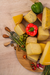 Image showing Bosnian traditional cheese served on a wooden container with peppers, parade and onions isolated on a white background