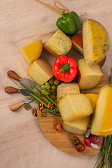 Image showing Bosnian traditional cheese served on a wooden container with peppers, parade and onions isolated on a white background