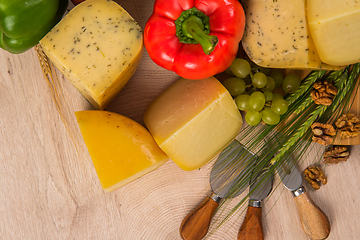 Image showing Bosnian traditional cheese served on a wooden container with peppers, parade and onions isolated on a white background