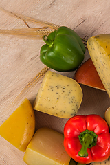 Image showing Bosnian traditional cheese served on a wooden container with peppers, parade and onions isolated on a white background