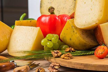 Image showing Bosnian traditional cheese served on a wooden container with peppers, parade and onions isolated on a white background