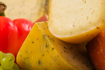 Image showing Bosnian traditional cheese served on a wooden container with peppers, parade and onions isolated on a white background