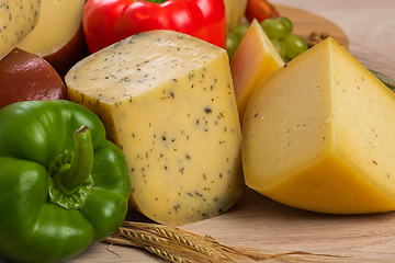 Image showing Bosnian traditional cheese served on a wooden container with peppers, parade and onions isolated on a white background