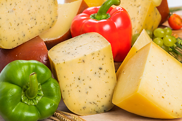 Image showing Bosnian traditional cheese served on a wooden container with peppers, parade and onions isolated on a white background