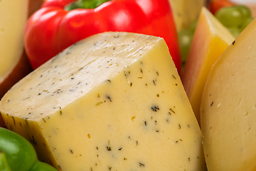 Image showing Bosnian traditional cheese served on a wooden container with peppers, parade and onions isolated on a white background