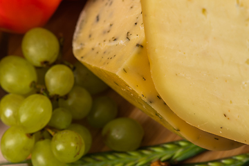 Image showing Bosnian traditional cheese served on a wooden container with peppers, parade and onions isolated on a white background