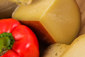 Image showing Bosnian traditional cheese served on a wooden container with peppers, parade and onions isolated on a white background