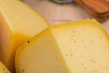 Image showing Bosnian traditional cheese served on a wooden container with peppers, parade and onions isolated on a white background